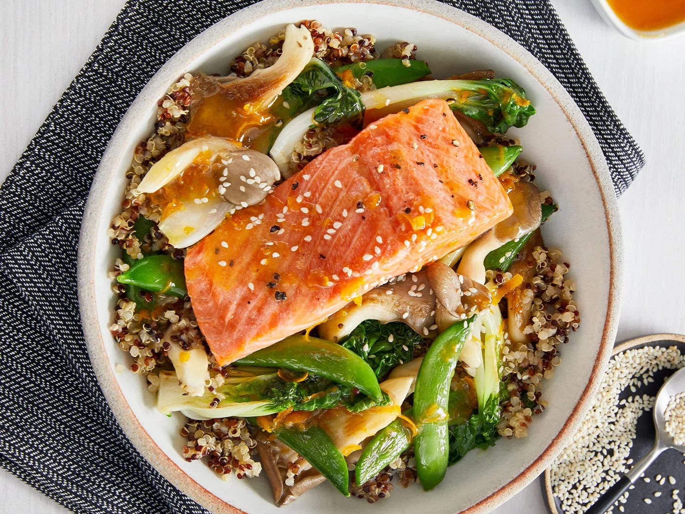 Roasted salmon, grains and vegetables in a colorful balanced bowl